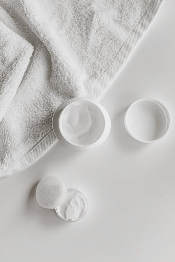 Mastering the First Impression: Your intriguing post title goes here Top view of skincare products and towel on a white surface, showcasing minimalism.